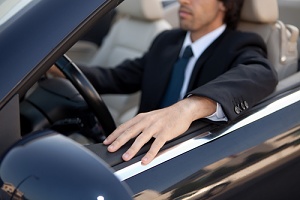 a chauffeur pulling up in a luxury fleet vehicle